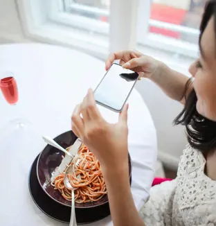 Jeune femme photographiant son assiette