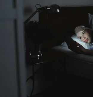 Femme dans son lit avec son téléphone